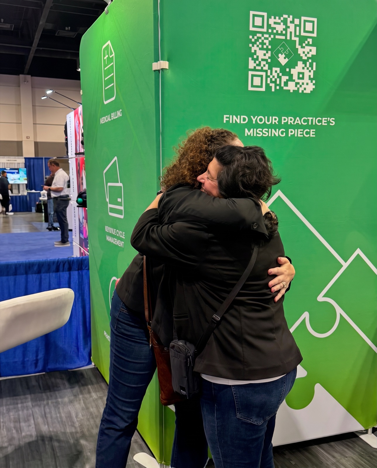 A CBS Medical Billing team member hugging a customer at the CBS conference booth
