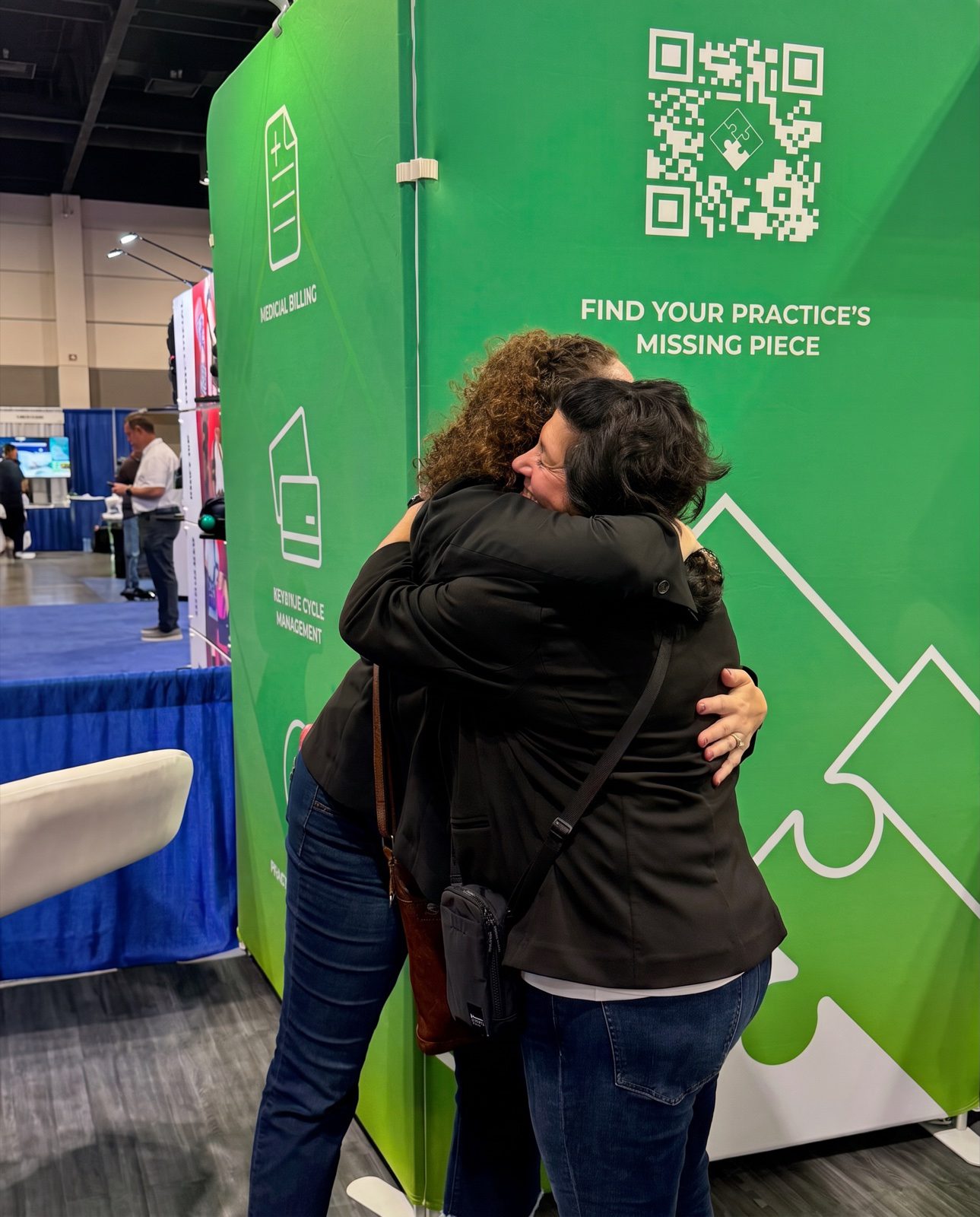 A CBS Medical Billing team member hugging a customer at the CBS conference booth